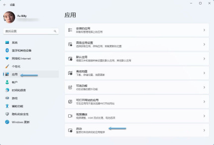 Windows 11中文设置的应用页面，箭头指向左侧应用与下方启动入口，证明进入系统启动设置的路径