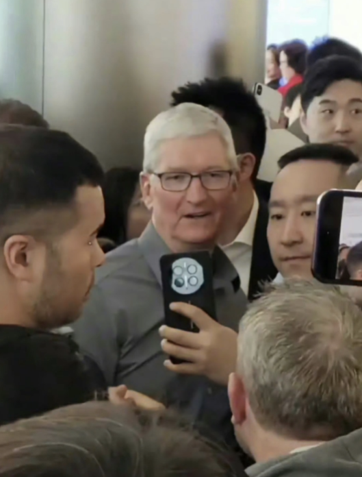 Apple CEO Cook visits China: A woman holds a Huawei Mate60 and takes a photo with him