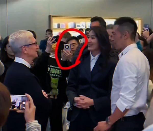 Apple-Chef Cook besucht China: Eine Frau hält ein Huawei Mate60 in der Hand und macht ein Foto mit ihm