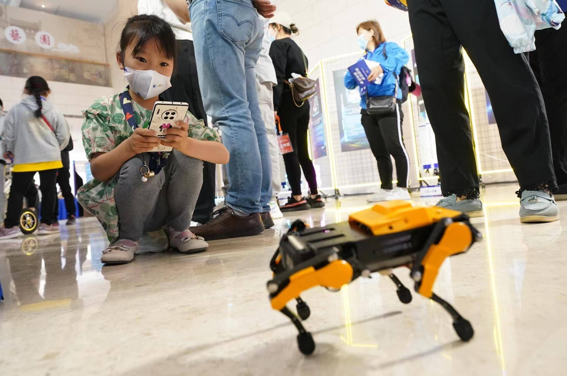 Di atas jejambat, robot dan anjing mekanikal sedang membuat persembahan secara langsung hari ini! Penonton kecil adalah yang paling gembira